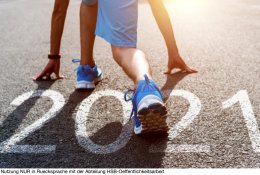 Young sports man preparing to run with number 2021 on the road