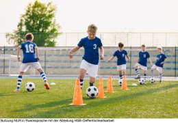 Soccer Training - Warm Up and Slalom Drills. Boys Practicing European Soccer on the Grass School Field