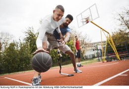 Young man with artificial limb on a basketball court