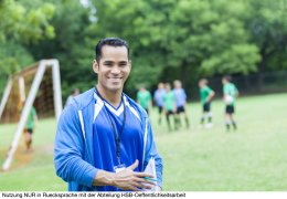 Hispanic soccer coach smiles confidently before game